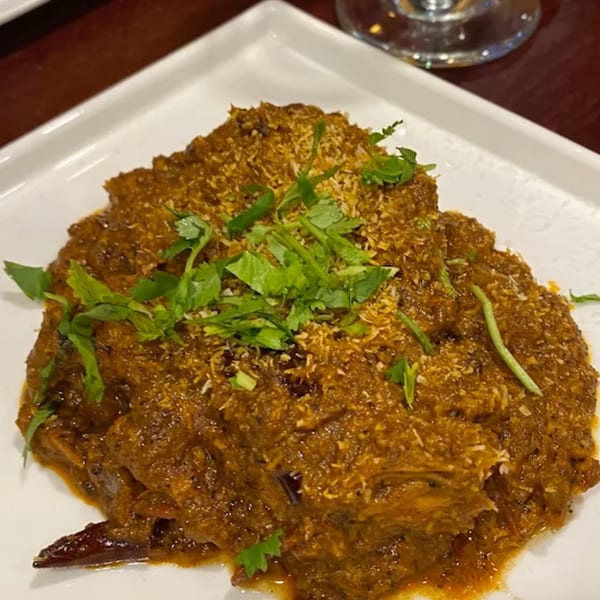 Indian curry dish from Spice Kitchen, garnished with fresh cilantro and shredded coconut.